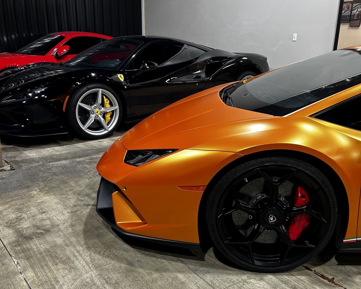 Orange Lamborghini Huracán and black Ferrari in the shop in Lexington, KY