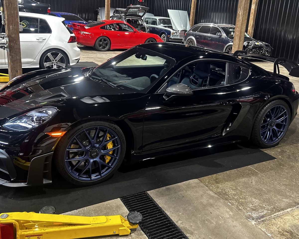 Black Porsche Cayman in the service bay at Bluegrass Precision Motorwerks